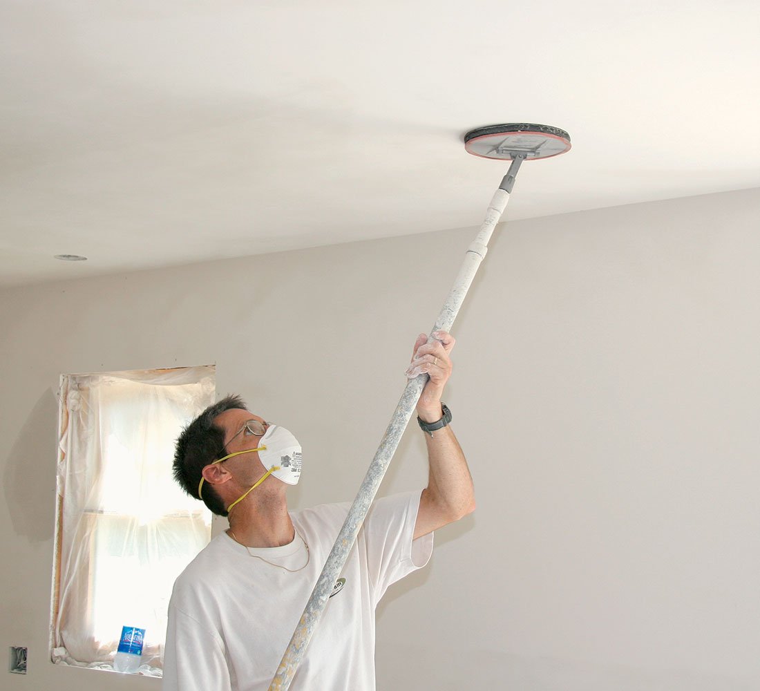 Professional painter pole sanding interior walls between coats for a smooth, even finish – Southeast Michigan painting preparation.