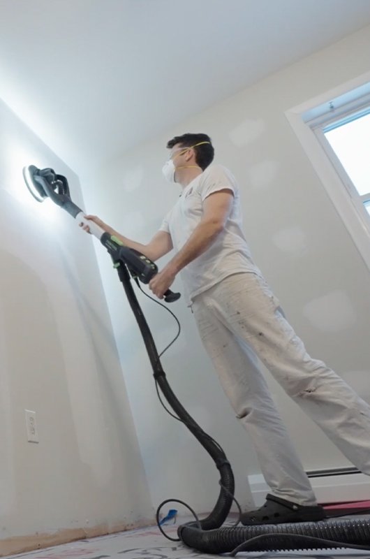 Power sanding interior wall with dust control system – premium wall and ceiling restoration service for a like-new finish in Southeast Michigan.