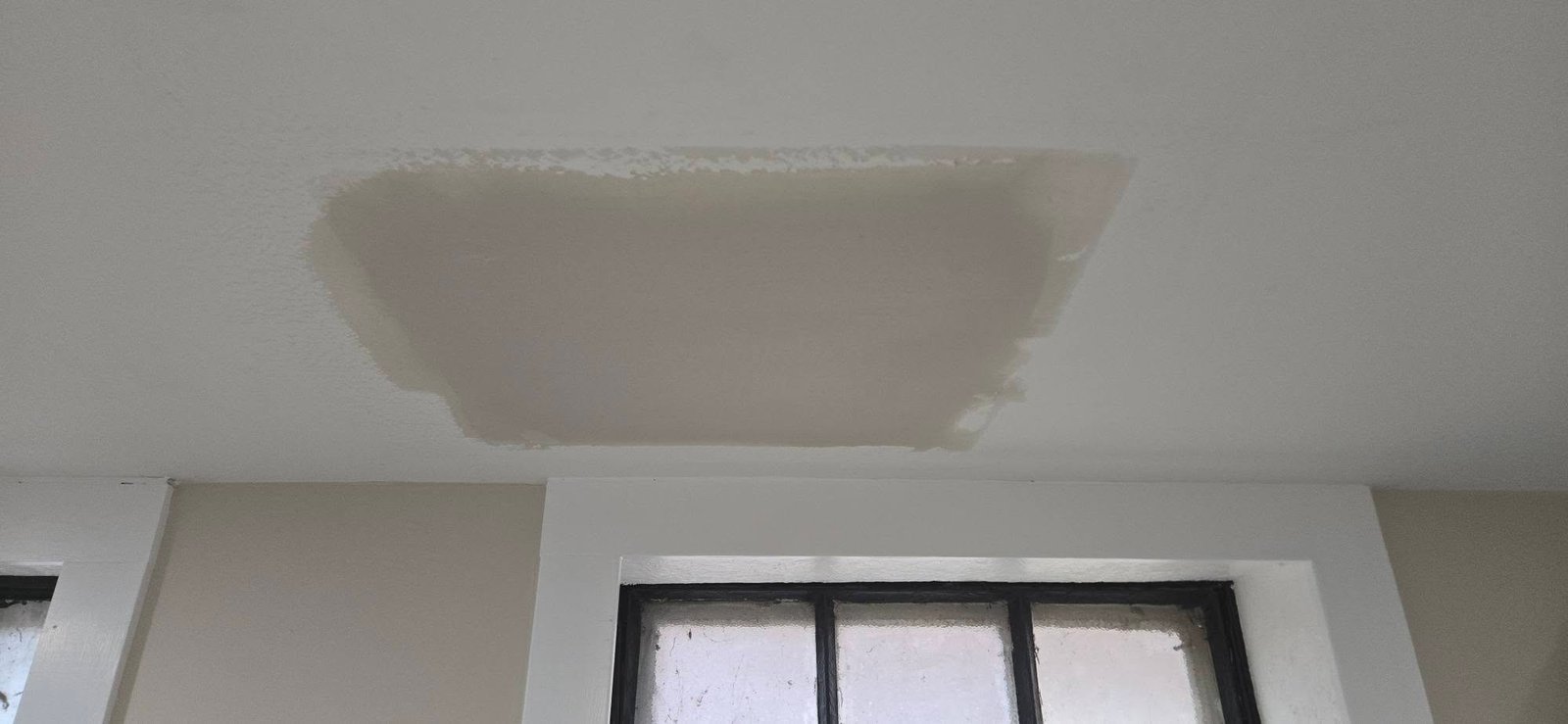 Drywall repair in progress during patching and smoothing