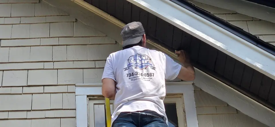 Five Star employee painting exterior trim on a home in Riverview Michigan