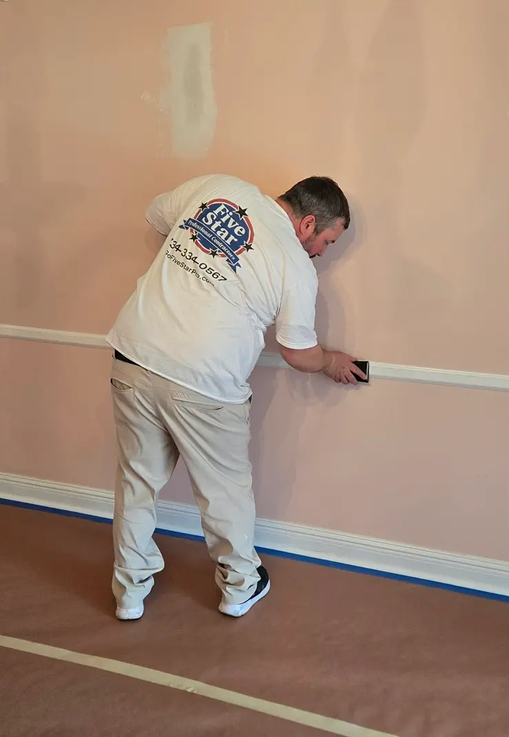 Trim sanding preparation before painting in Northville MI house