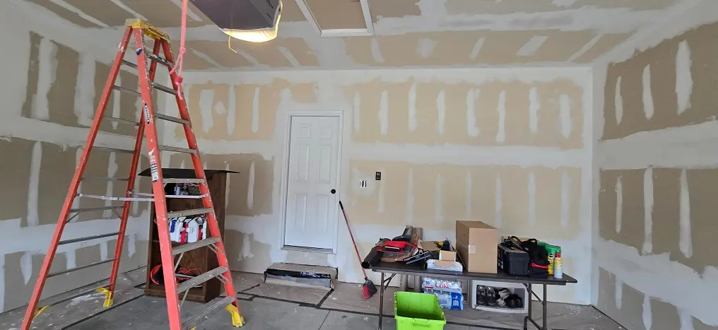 Unfinished garage before drywall finishing and interior painting in Metro Detroit MI with taped drywall seams and wall preparation underway